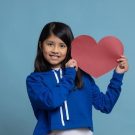beautiful-shot-of-a-mexican-girl-holding-a-red-hea-2023-11-27-05-27-18-utc