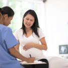 pcmc perinatology center service Hispanic Pregnant Woman Speaks With Her Doctor at a Check-Up stock photo